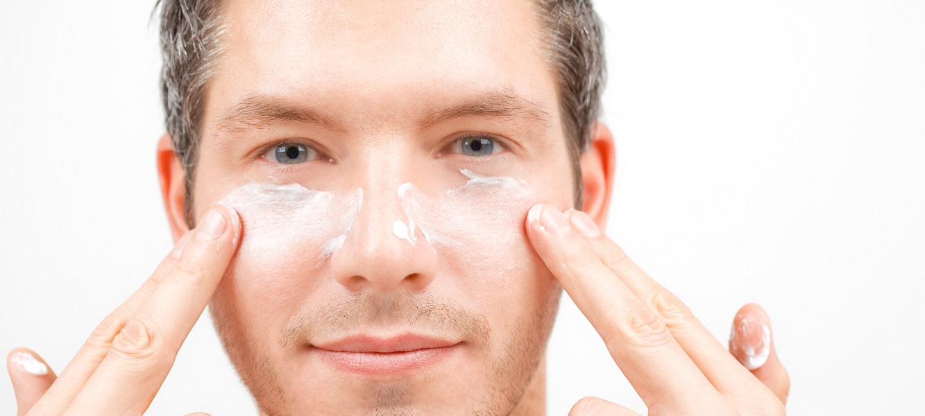 мужчина наосит крем на лицо