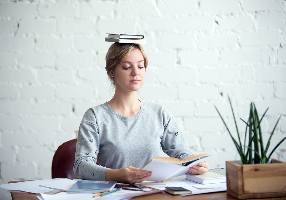 Девушка читает с книгой на голове
