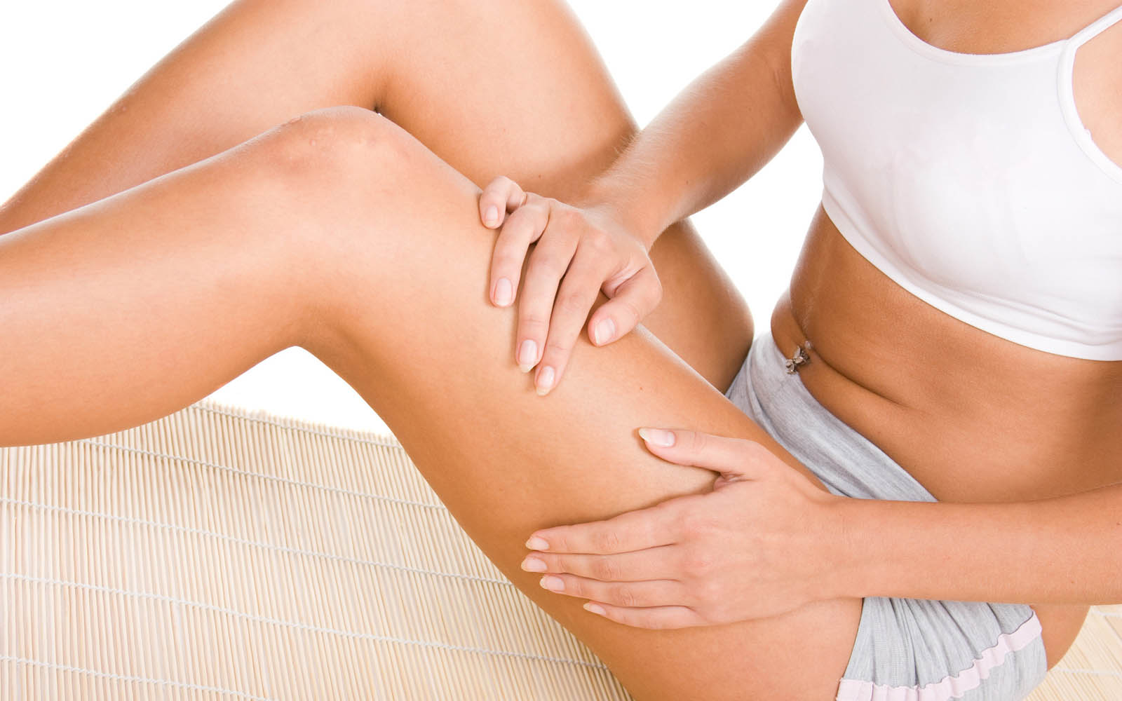 девушка наносит на ноги масло для тела