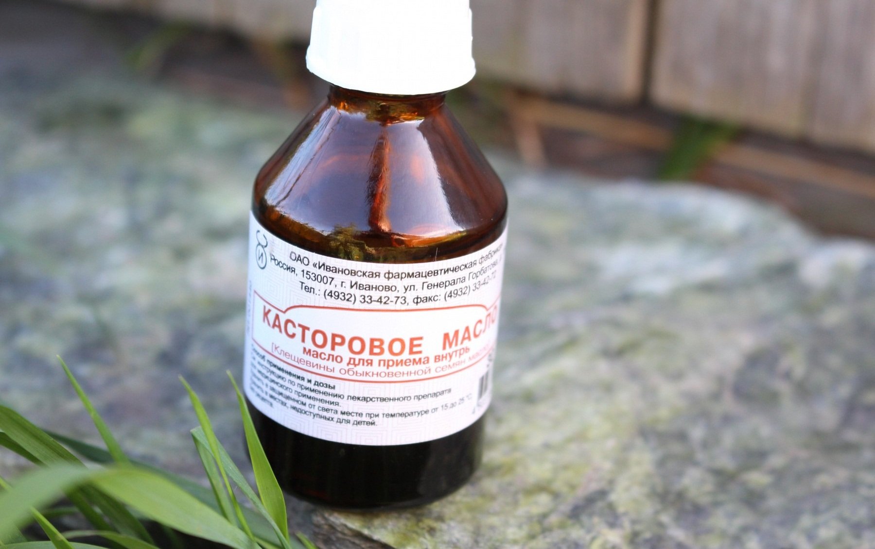 Флакон с касторовым маслом на каменном полу