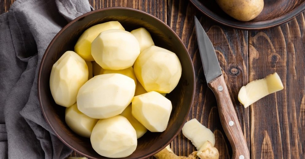 Сырой очищенный картофель в миске